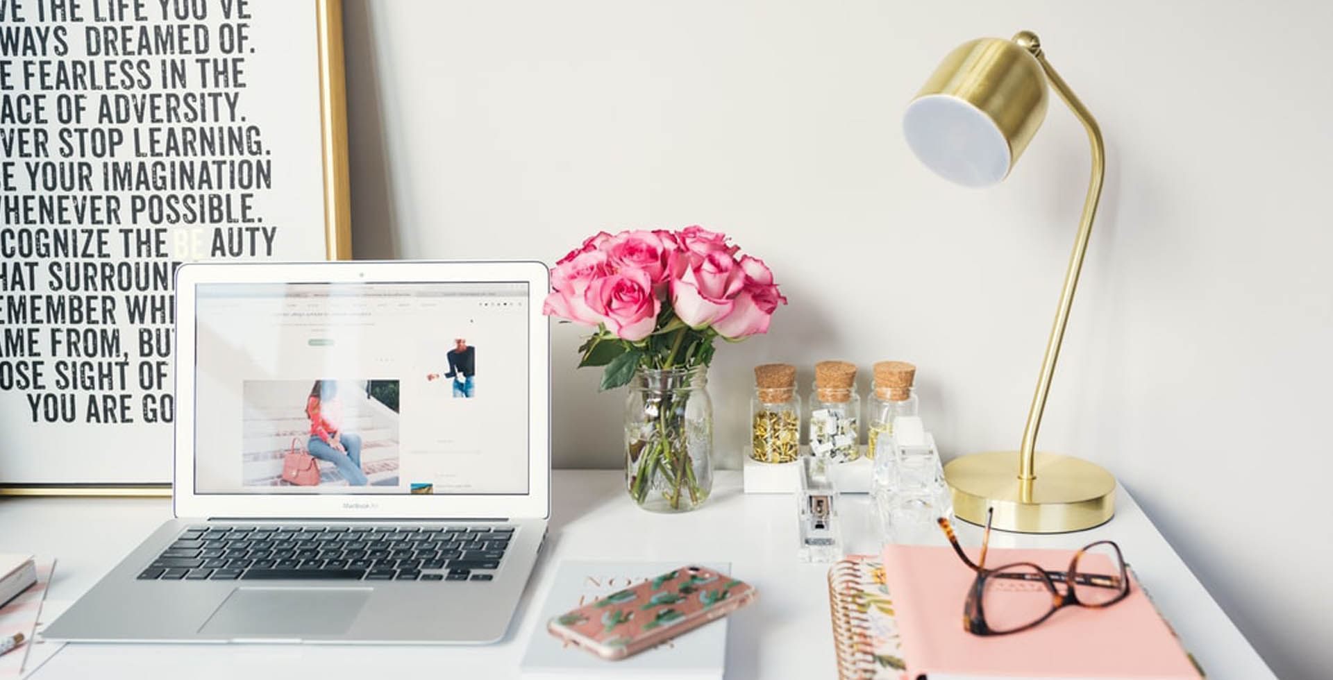 A stylish desk with a laptop, bouquet of roses and gold lamp at Sunway Hotel Georgetown